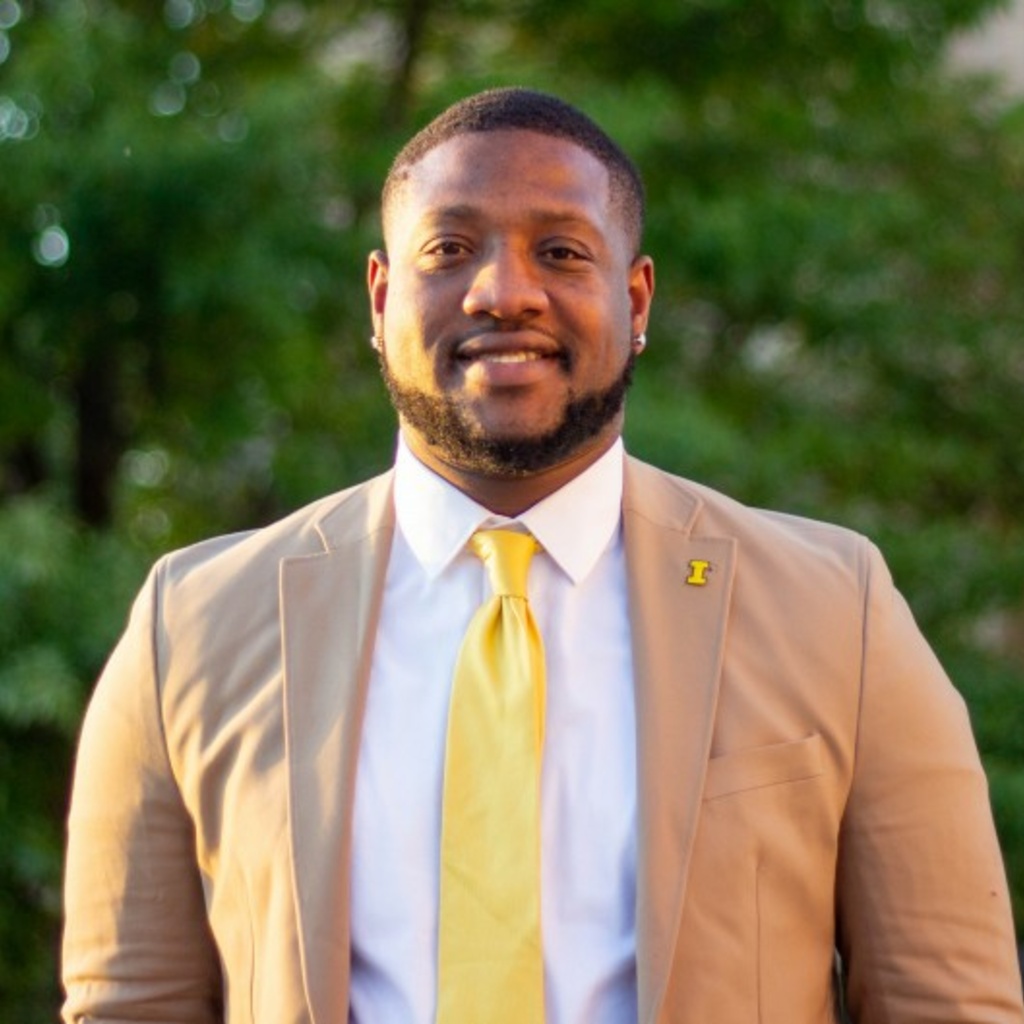 Jamarco standing and smiling in front of a background of trees