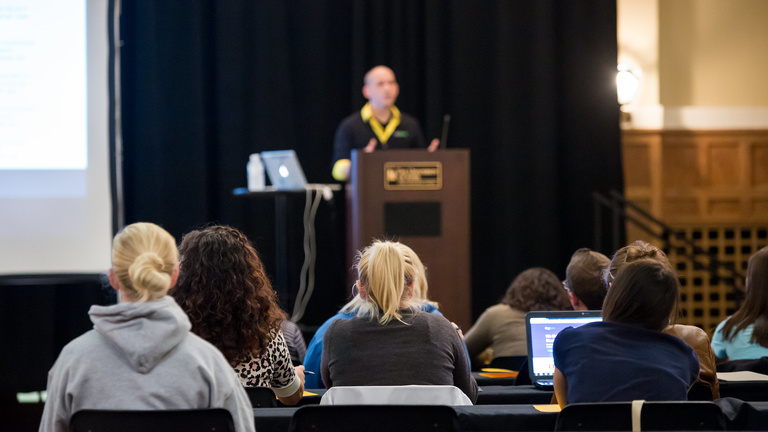 person on stage giving presentation